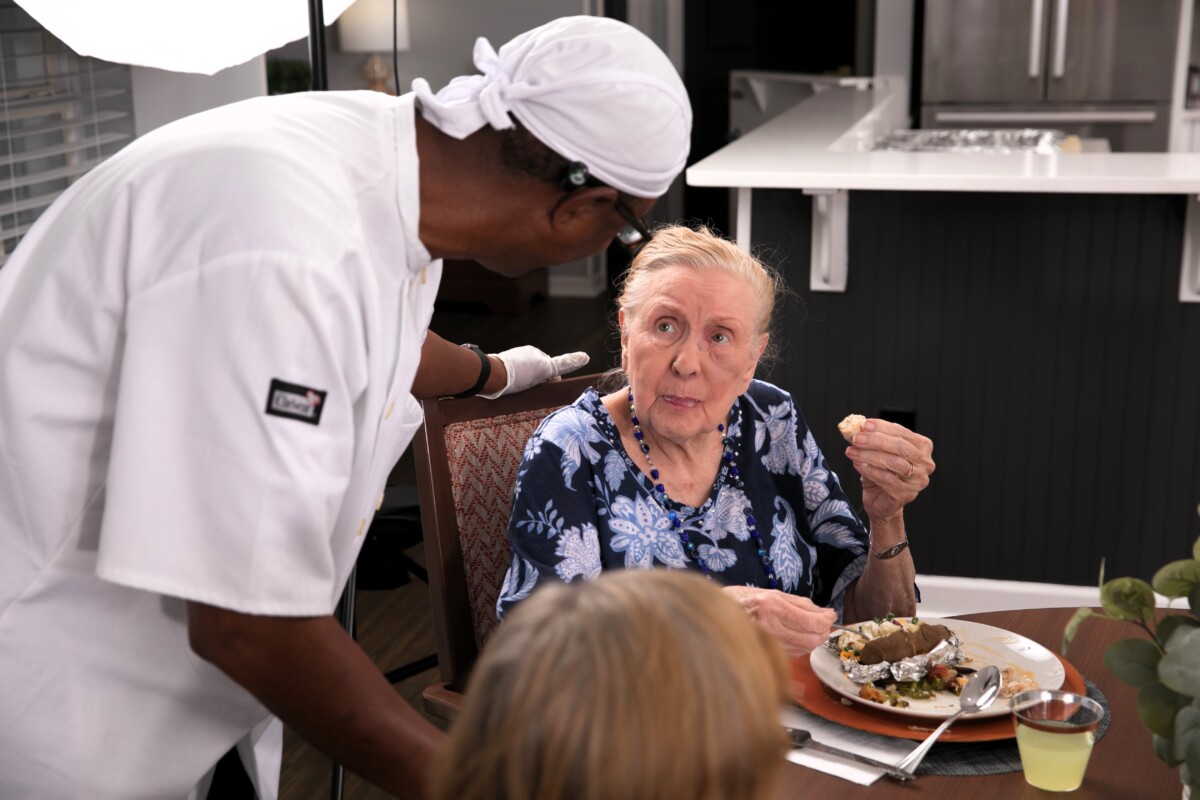 Chef checking on resident at a dining table