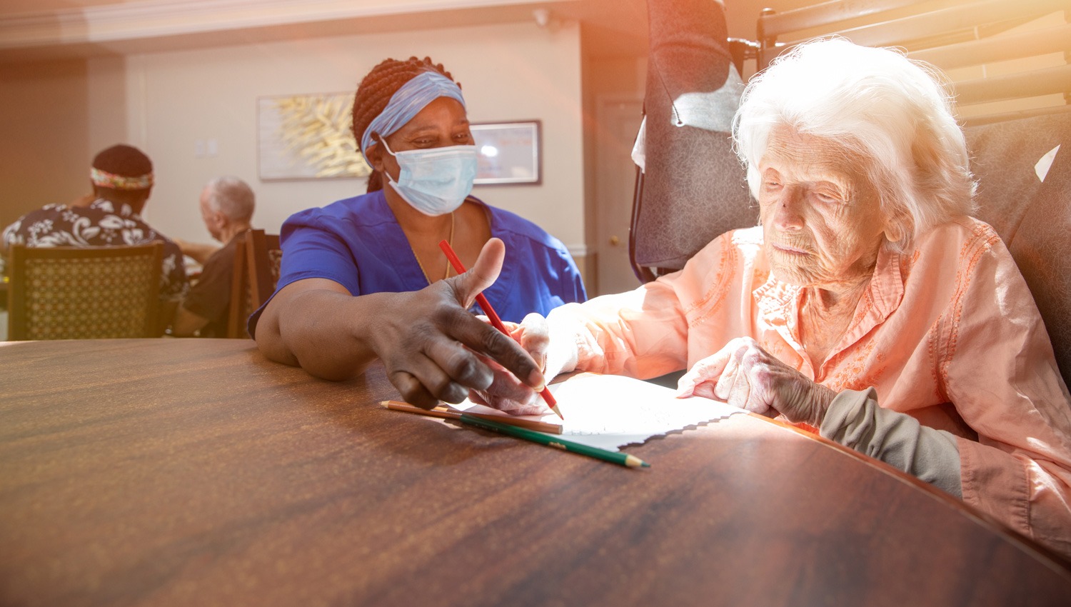 assisted living resident and caregiver completing an activity