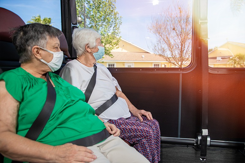Palm-Cottages-couple two elder care residents on bus to go to on outing