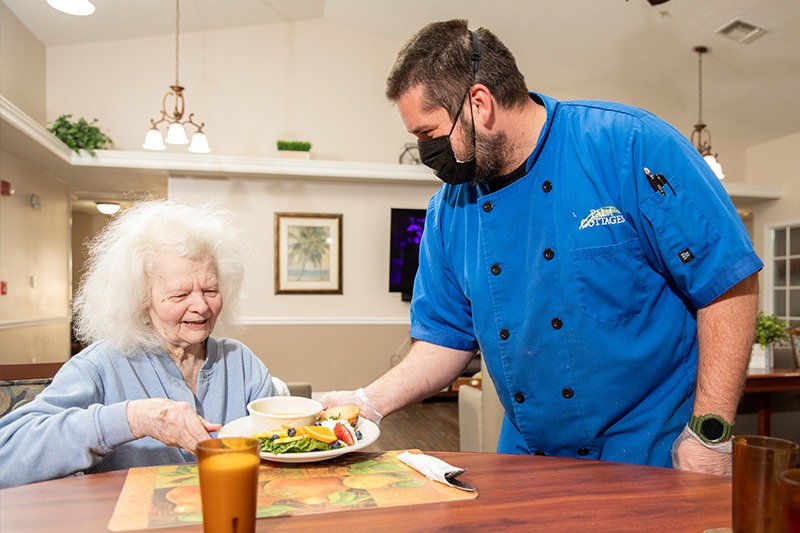 female patient being served a meal by a male care provider