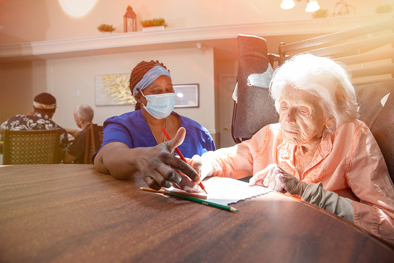 female alzheimer's care facility patient reviewing paper with care provider